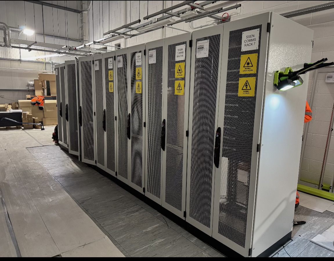 Row of grey network comms cabinets installed on site